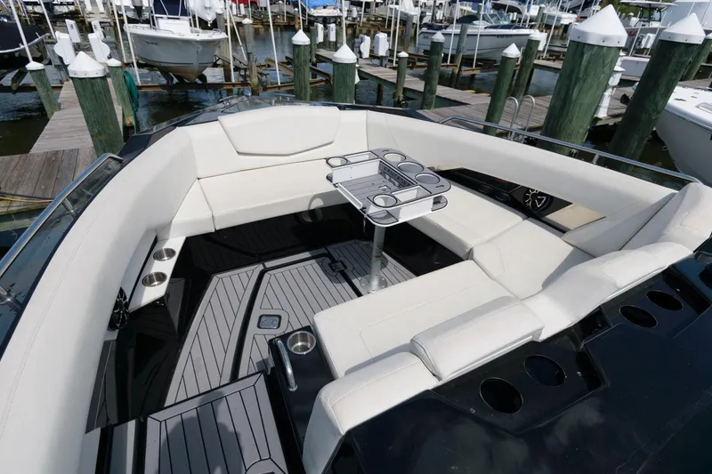 Slide: The Image of 2020 Cruisers Yachts 338 SS OB interior with white seating and table at marina. - 9