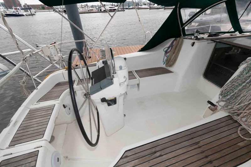 Slide: The Image of Cockpit of 2003 Beneteau 393 sailboat with steering wheel and teak flooring. - 11