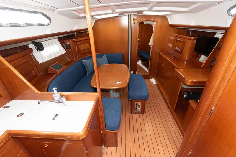 Slide: The Image of Interior of 2003 Beneteau 393 yacht with wooden finish and blue seating. - 14