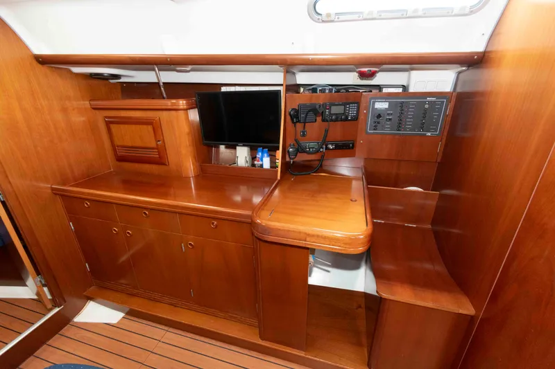 Slide: The Image of 2003 Beneteau 393 yacht interior with wooden cabinetry and navigation equipment. - 18