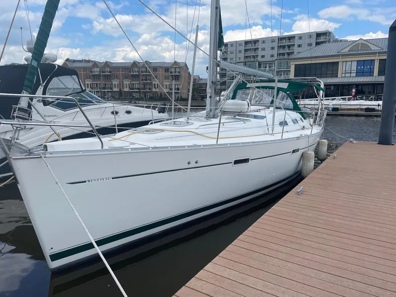 Slide: The Image of 2003 Beneteau 393 sailboat docked at marina with buildings in background. - 2