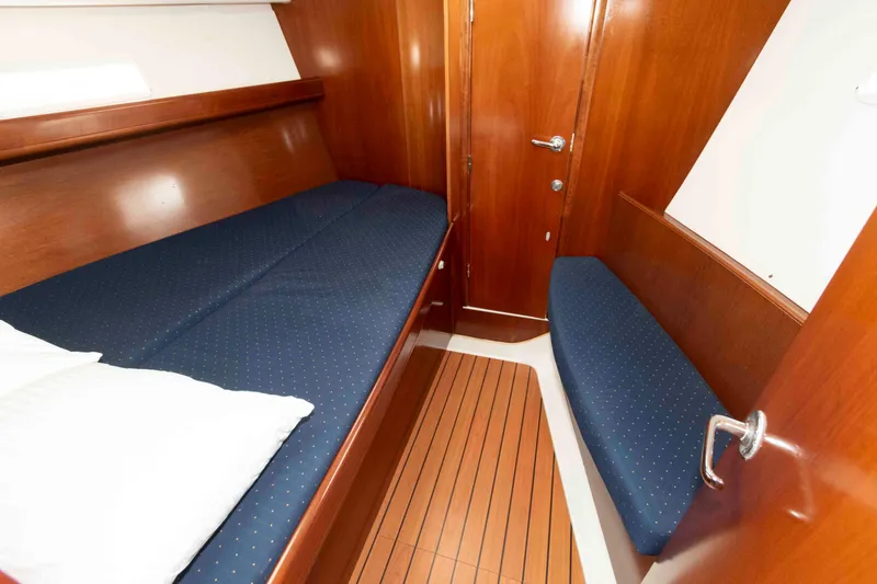 Slide: The Image of 2003 Beneteau 393 cabin interior with wooden finish and blue upholstery. - 21