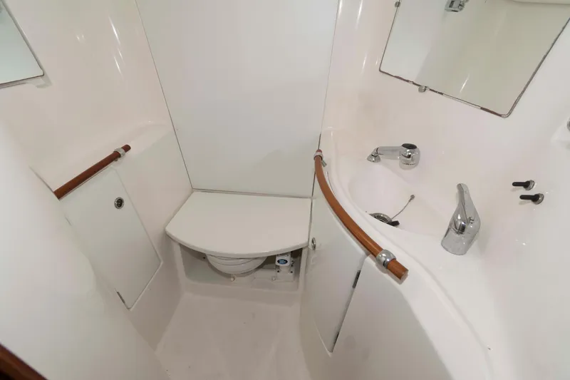 Slide: The Image of 2003 Beneteau 393 yacht bathroom with compact design, white fixtures, and wooden accents. - 22