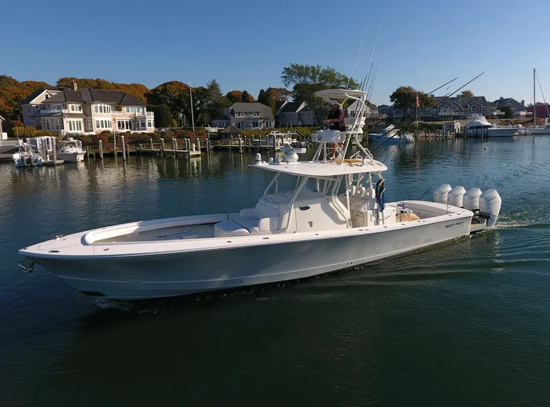 Slide: The Image of 2017 Regulator 41 boat cruising in a scenic waterfront area with houses and trees. - 2