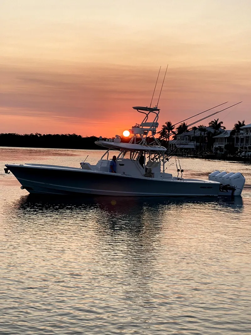 Slide: The Image of 2017 Regulator 41 boat at sunset on calm water, silhouetted against an orange sky. - 42