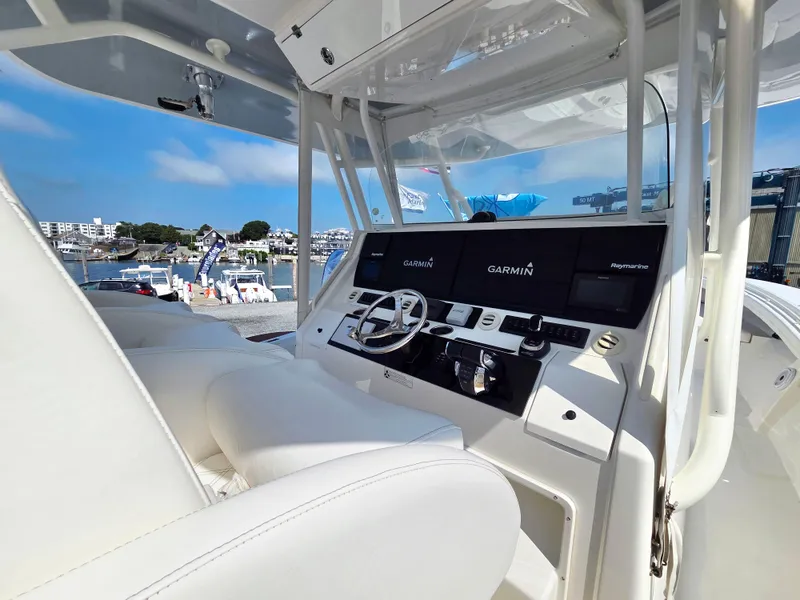 Slide: The Image of 2017 Regulator 41 boat helm with Garmin navigation, docked at marina under clear blue sky. - 6