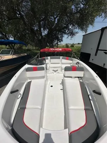 Slide: The Image of 2022 Tracker T16 boat interior with white and red seating, parked outdoors. - 10