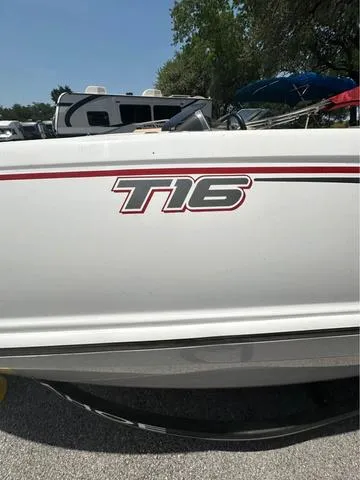 Slide: The Image of 2022 Tracker T16 boat with red stripe detail, parked outdoors. - 12