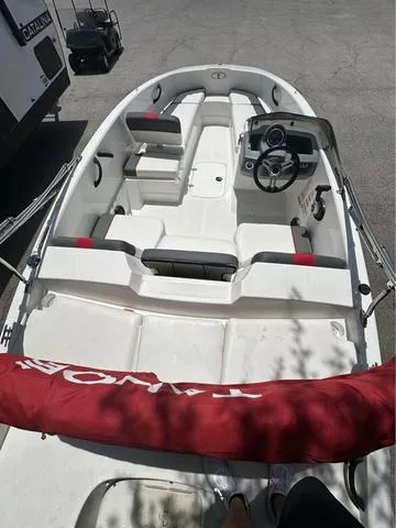 Slide: The Image of 2022 Tracker T16 boat with seating and steering console, parked on pavement. - 7