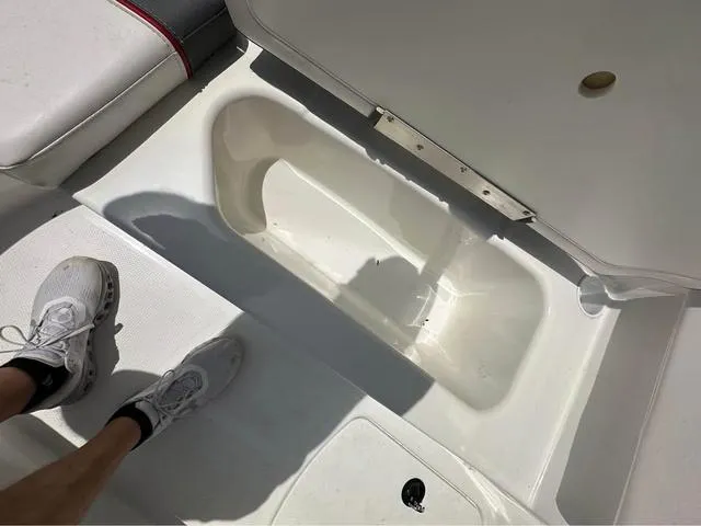 Slide: The Image of Open storage compartment on a 2022 Tracker T16 boat, with visible seating and footwear. - 9