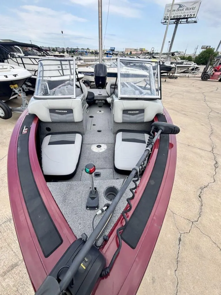 Slide: The Image of 2018 Tracker Targa™ V-18 WT boat interior with seating and controls, parked at a dealership. - 3