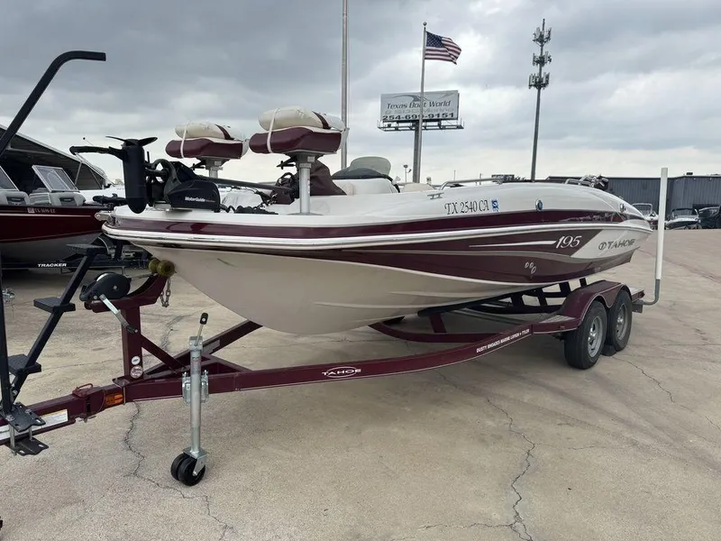 Slide: The Image of 2013 Tahoe 195 boat on trailer, parked outdoors under cloudy sky. - 3