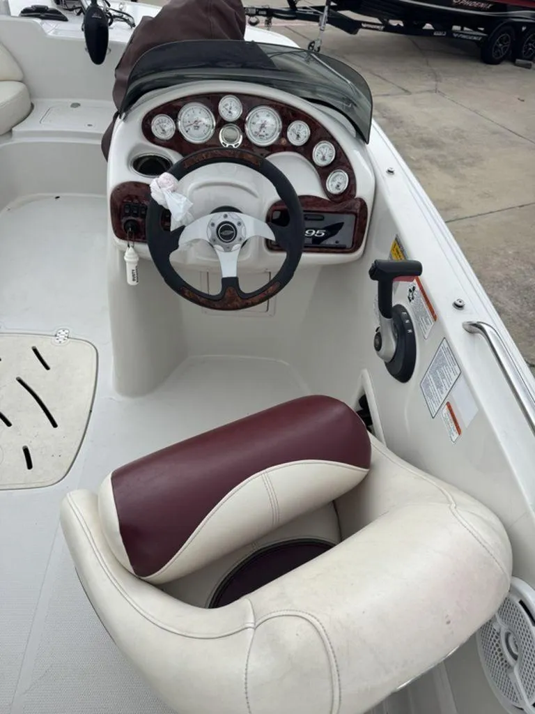 Slide: The Image of Steering console of a 2013 Tahoe 195 boat with gauges and maroon seat. - 5