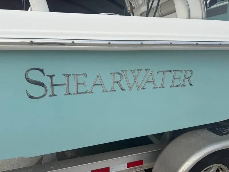 Slide: The Image of 2017 ShearWater 270 Carolina Flare boat with logo on light blue hull. - 8
