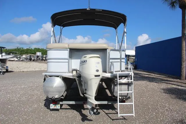 Slide: The Image of 2019 Misty Harbor Adventure CF A-1885CF pontoon boat with Suzuki outboard motor, parked on gravel. - 5