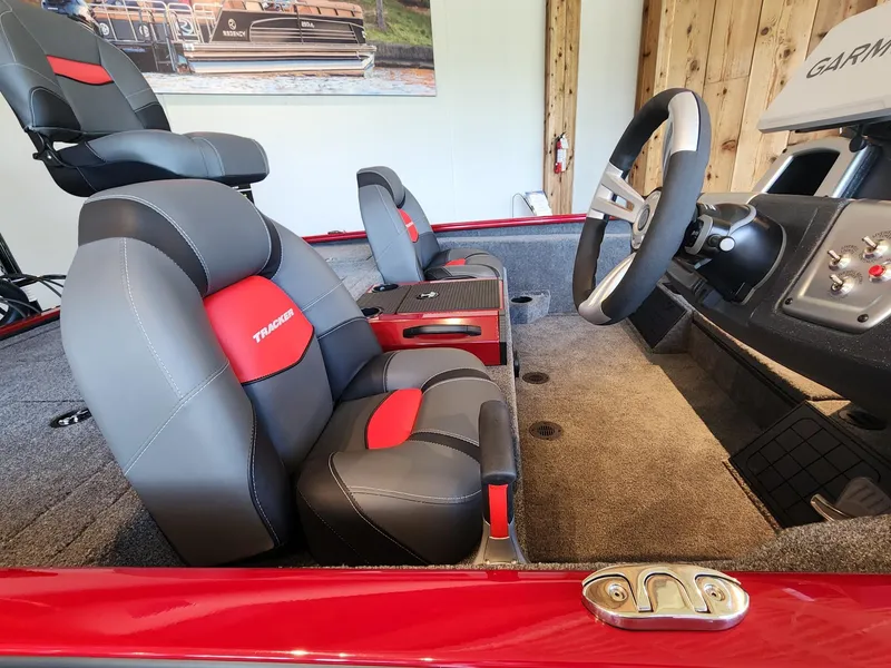 Slide: The Image of 2025 Tracker Savage 215 boat interior with red and gray seating, steering wheel, and control panel. - 5