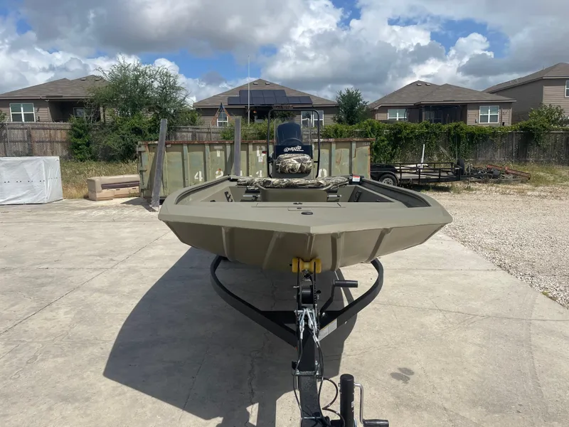 Slide: The Image of 2025 Tracker Grizzly 1860 CC boat on trailer, parked outdoors under cloudy sky. - 2