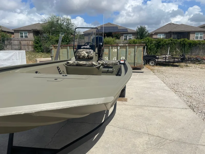 Slide: The Image of 2025 Tracker Grizzly 1860 CC boat parked outdoors on a sunny day. - 3