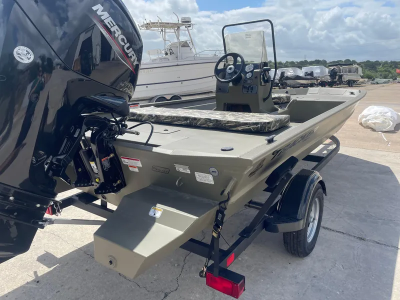 Slide: The Image of 2025 Tracker Grizzly 1860 CC boat with Mercury engine on trailer, outdoor setting. - 6