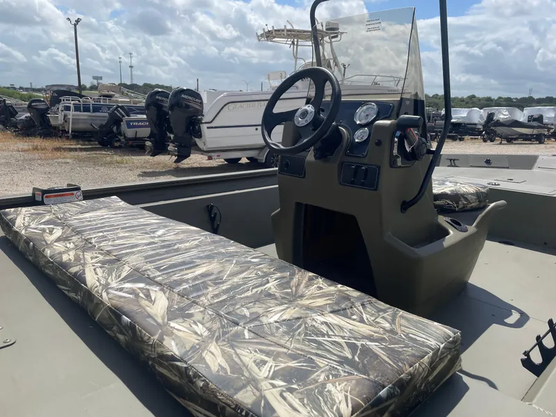 Slide: The Image of 2025 Tracker Grizzly 1860 CC boat interior with camo seating and steering console. - 7