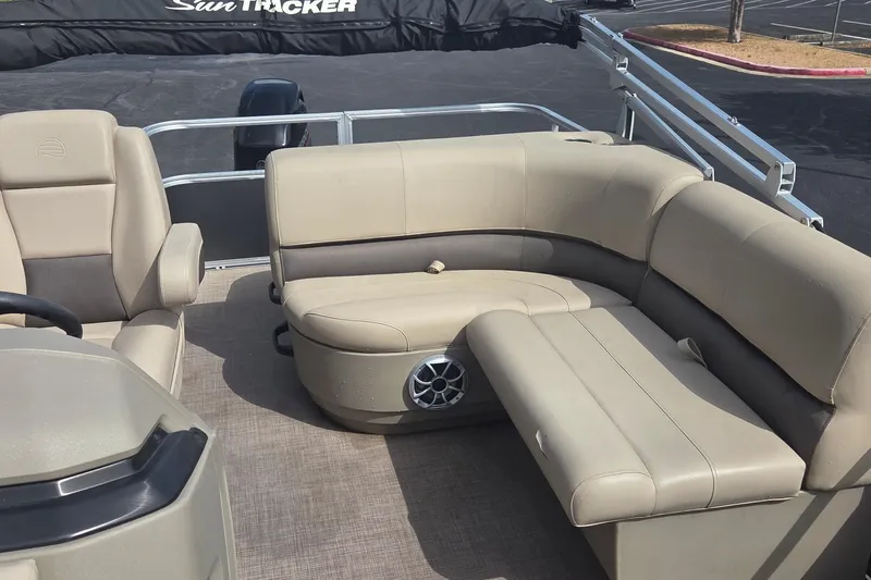 Slide: The Image of 2025 Sun Tracker Party Barge 18 DLX interior with beige seating and speaker system. - 7