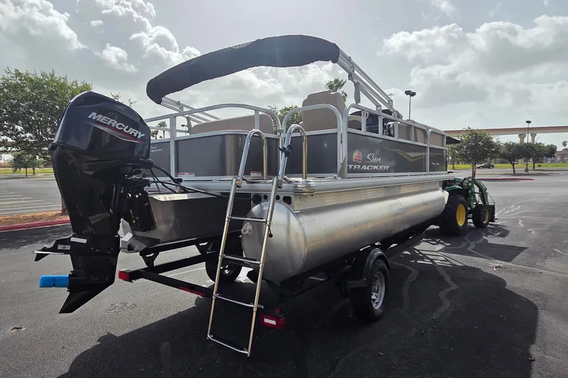 Slide: The Image of 2025 Sun Tracker Party Barge 18 DLX pontoon boat with Mercury engine on trailer. - 2