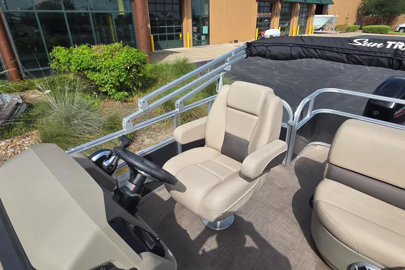 Slide: The Image of 2025 Sun Tracker Party Barge 18 DLX interior with beige captain's chair and steering console. - 9