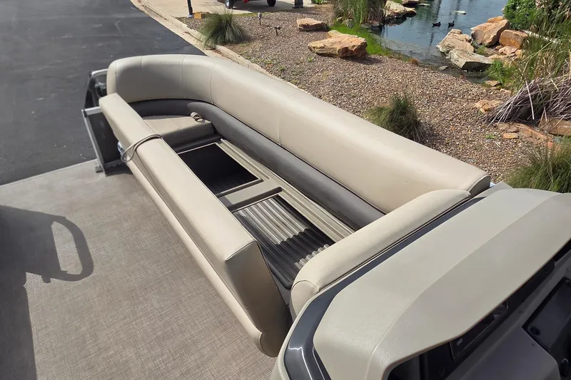 Slide: The Image of 2025 Sun Tracker Party Barge 18 DLX pontoon boat seating area, beige upholstery, outdoor setting. - 5