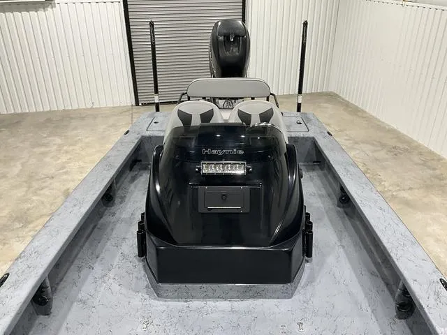 Slide: The Image of 2016 Haynie 25 Magnum boat in a garage, featuring dual seats and a sleek design. - 13