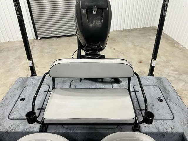 Slide: The Image of 2016 Haynie 25 Magnum boat interior with seating and motor in a garage setting. - 14