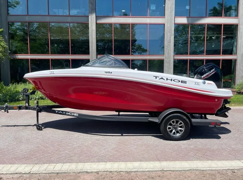 The Image of 2025 Tahoe 185 S boat in red on a trailer, parked outdoors. - 0