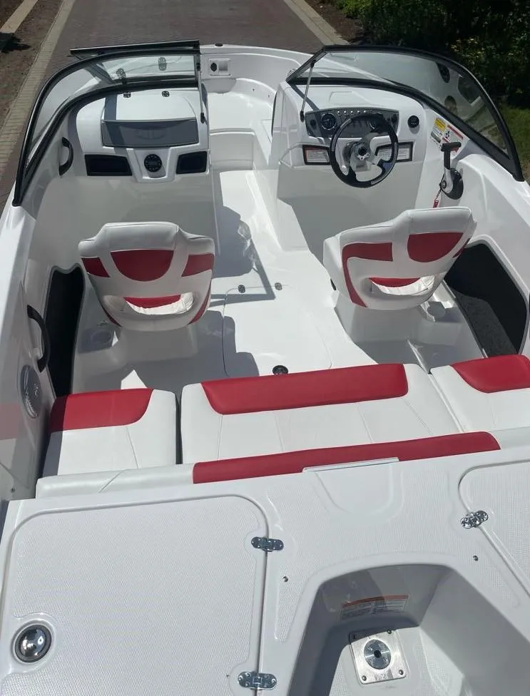 Slide: The Image of 2025 Tahoe 185 S boat interior with red and white seating, steering wheel, and dashboard. - 5