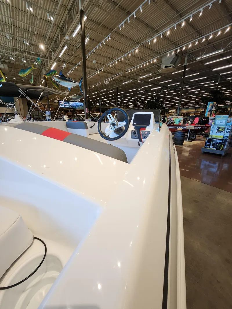 Slide: The Image of 2025 Tahoe T18 boat interior at a showroom, featuring steering wheel and control panel. - 2
