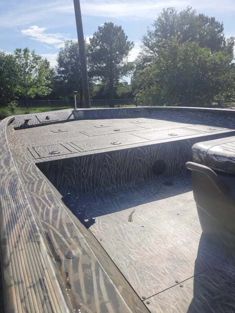 Slide: The Image of 2025 Tracker Grizzly 2072 CC boat with camo deck, surrounded by trees. - 6