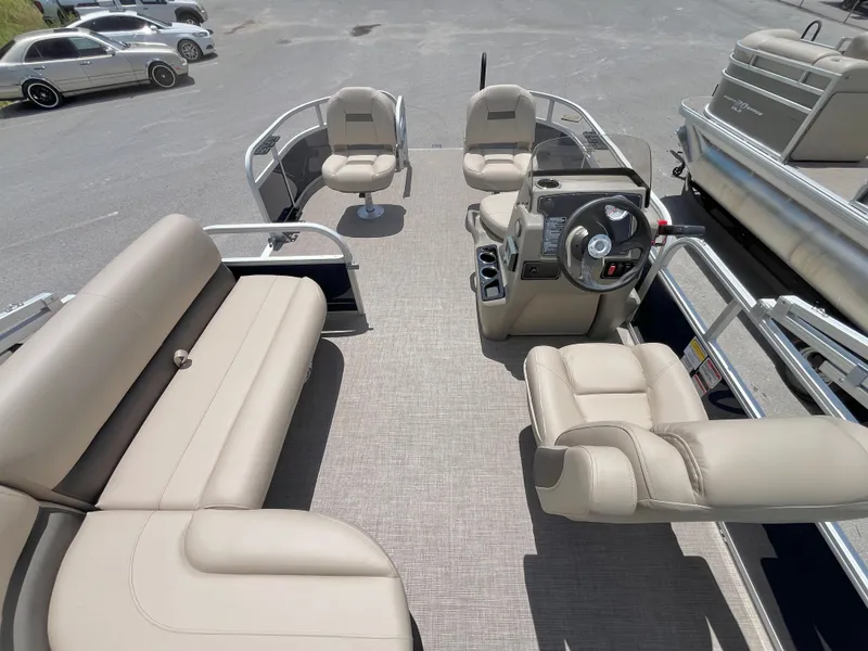 Slide: The Image of 2025 Sun Tracker Bass Buggy 16 XL Select pontoon boat interior with beige seating and steering console. - 4
