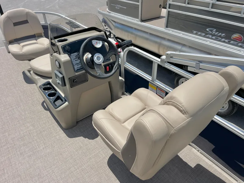 Slide: The Image of 2025 Sun Tracker Bass Buggy 16 XL Select boat interior with beige seating and steering console. - 6