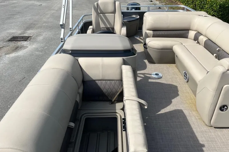 Slide: The Image of 2025 Sun Tracker Fishin' Barge 20 DLX interior with beige seating and storage compartments. - 10