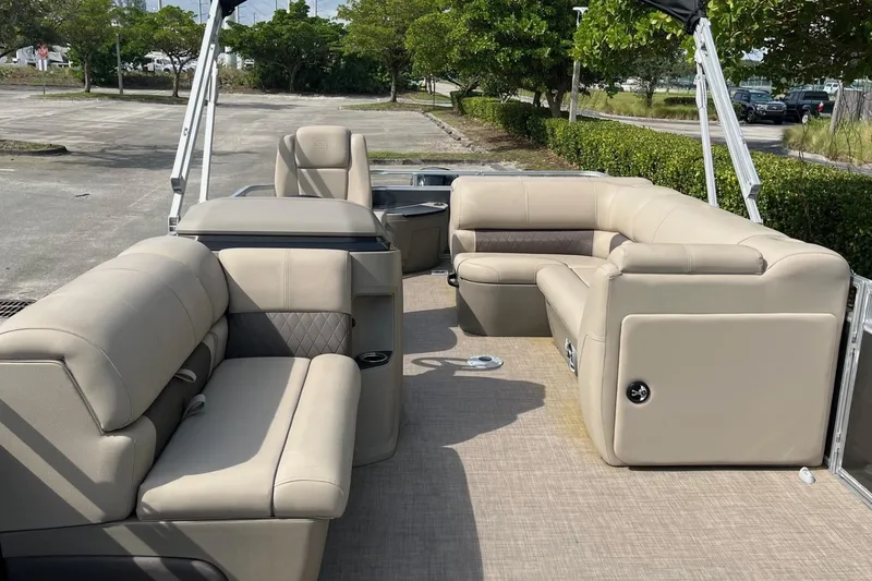 Slide: The Image of 2025 Sun Tracker Fishin' Barge 20 DLX interior with beige seating and spacious layout. - 8
