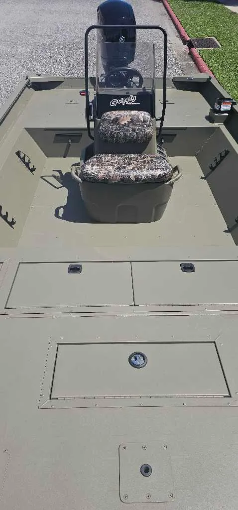 Slide: The Image of 2025 Tracker Grizzly 2072 CC boat interior with camo seat and storage compartments. - 4