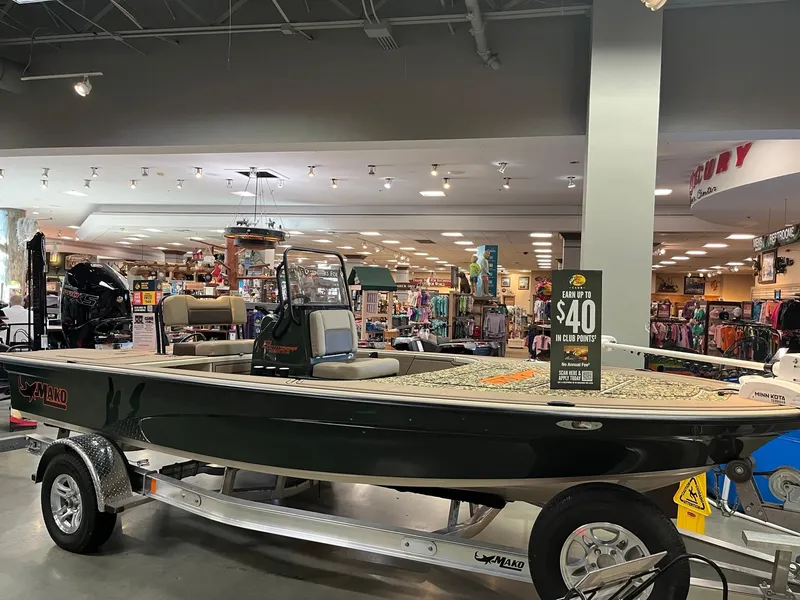 Slide: The Image of 2025 Mako 18 Pro Skiff Backwater Edition displayed in a showroom on a trailer. - 0