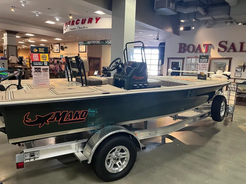 Slide: The Image of 2025 Mako 18 Pro Skiff Backwater Edition displayed in a boat sales showroom. - 2