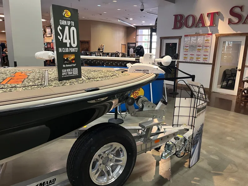 Slide: The Image of 2025 Mako 18 Pro Skiff Backwater Edition on display in a showroom with promotional sign. - 4