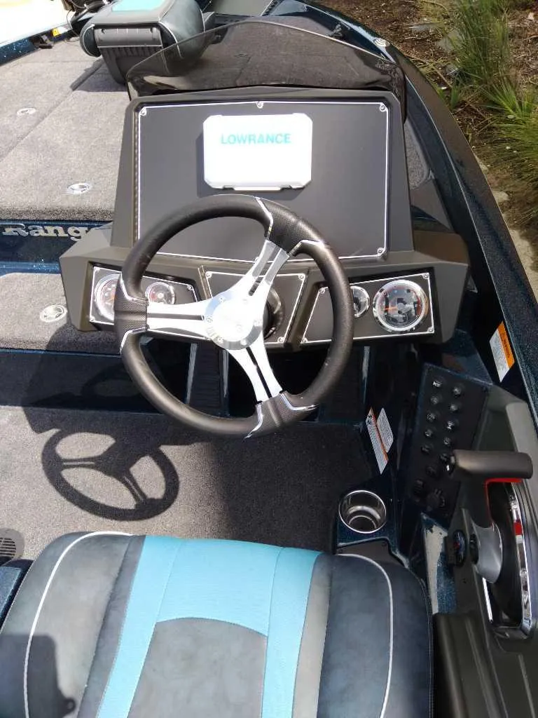 Slide: The Image of 2025 Ranger Z518 boat dashboard with steering wheel and Lowrance display. - 2