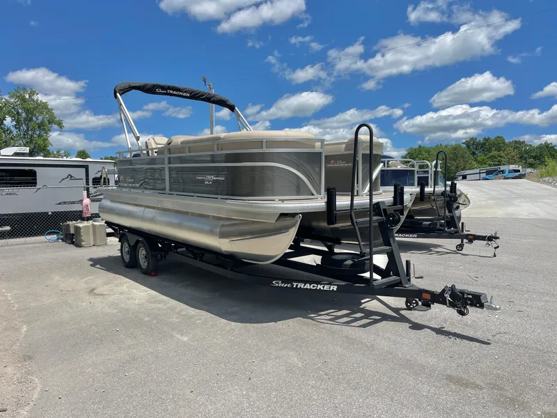Slide: The Image of 2025 Sun Tracker Party Barge 20 DLX pontoon boat on trailer under blue sky. - 17