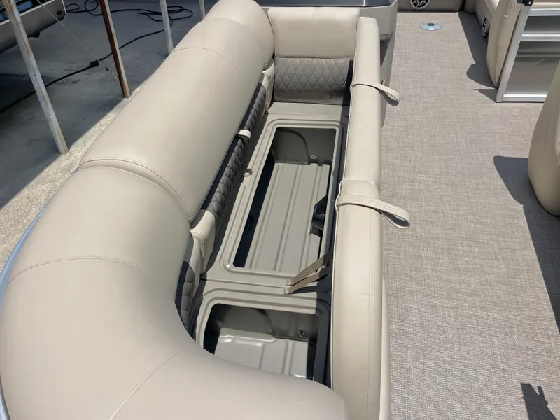 Slide: The Image of 2025 Sun Tracker Party Barge 20 DLX interior seating with storage compartment open. - 6