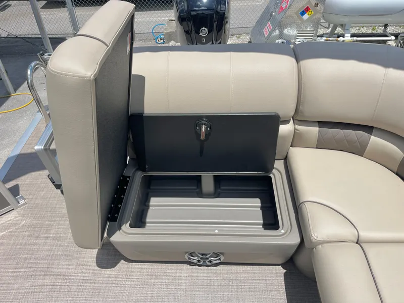 Slide: The Image of 2025 Sun Tracker Party Barge 20 DLX storage compartment with beige seating and open lid. - 7