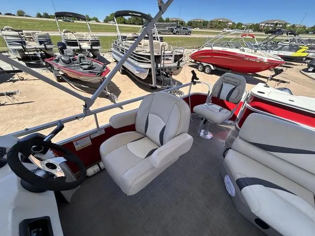 Slide: The Image of 2015 SunCatcher V20 F boat interior with steering wheel and seating, surrounded by other boats. - 11