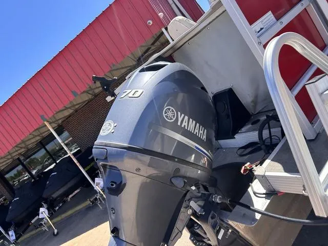 Slide: The Image of Yamaha 70 outboard motor on 2015 SunCatcher V20 F boat, parked outside a building. - 4