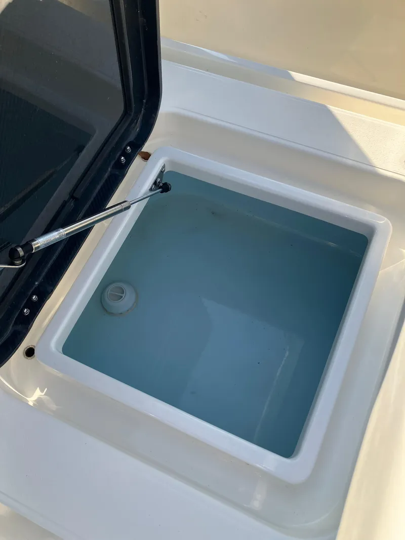 Slide: The Image of 2024 Islamorada Boatworks Morada 18 livewell with open lid, showcasing interior water. - 11