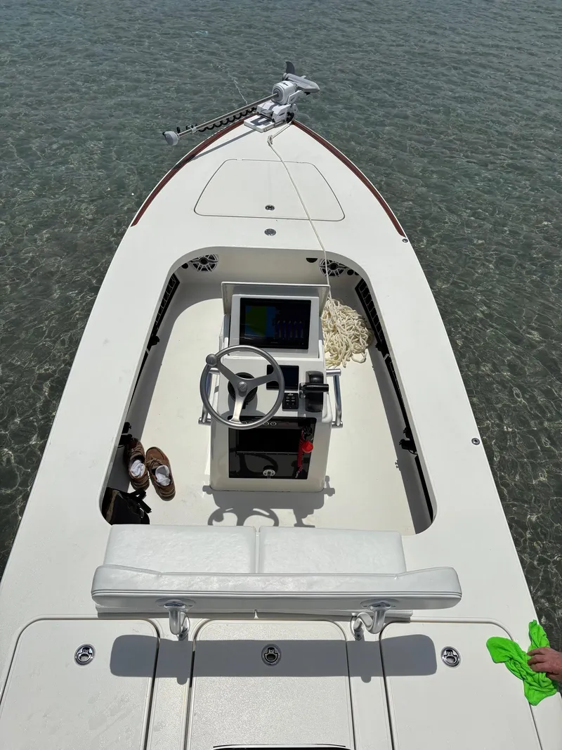 Slide: The Image of 2024 Islamorada Boatworks Morada 18 on calm water, featuring a sleek console and steering wheel. - 4